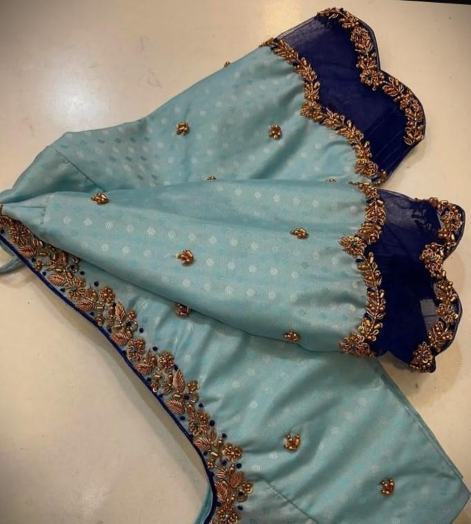 Decorative floating image of intricate golden Zardozi embroidery.